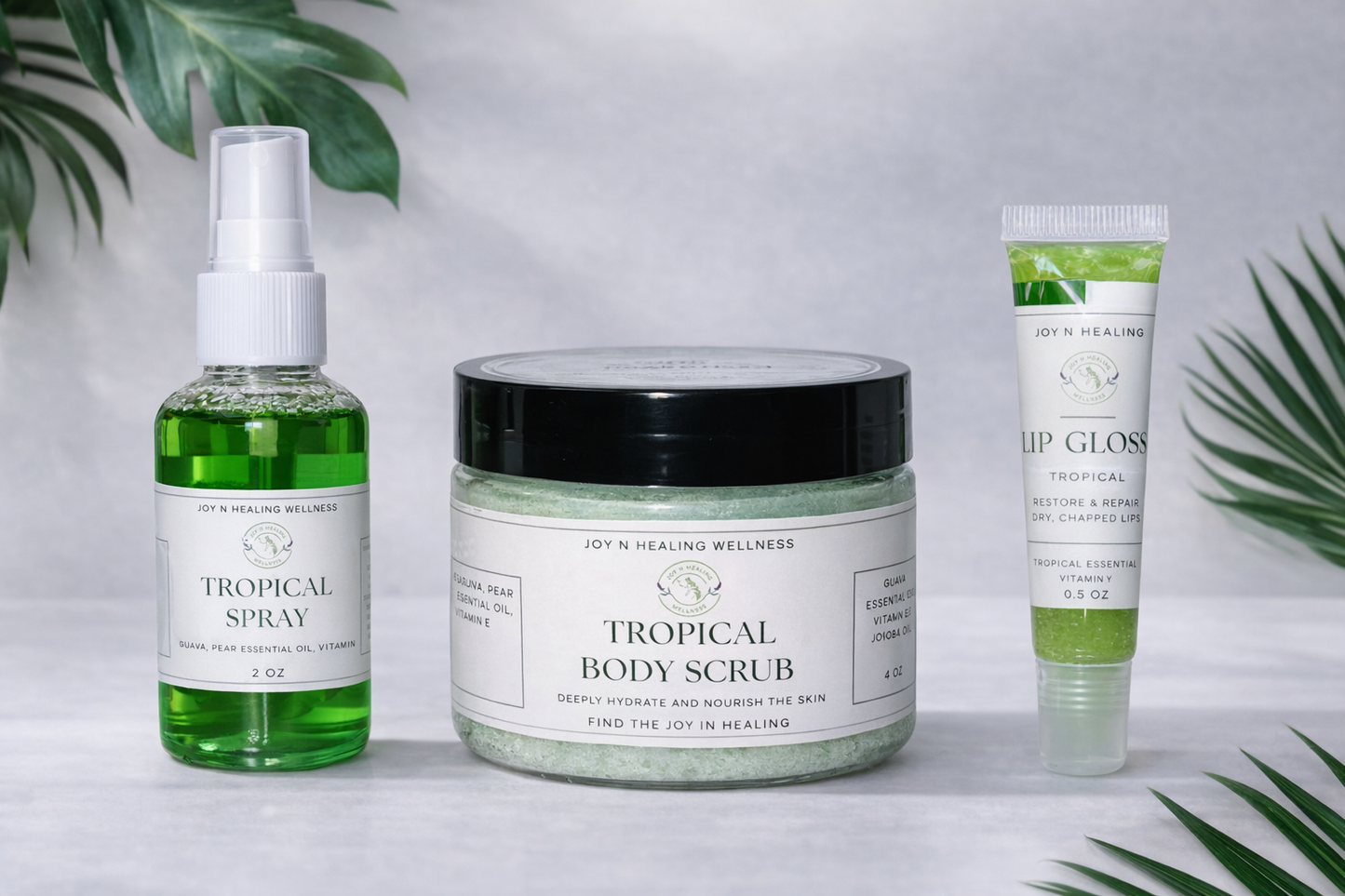 Tropical-themed skincare products including a spray, scrub, and lip gloss on a light background with green leaves.