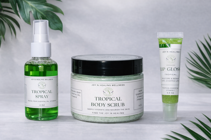 Tropical-themed skincare products including a spray, scrub, and lip gloss on a light background with green leaves.