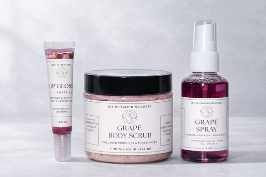 Collection of grape-themed skincare products including lip gloss, body scrub, and spray on a light gray background.