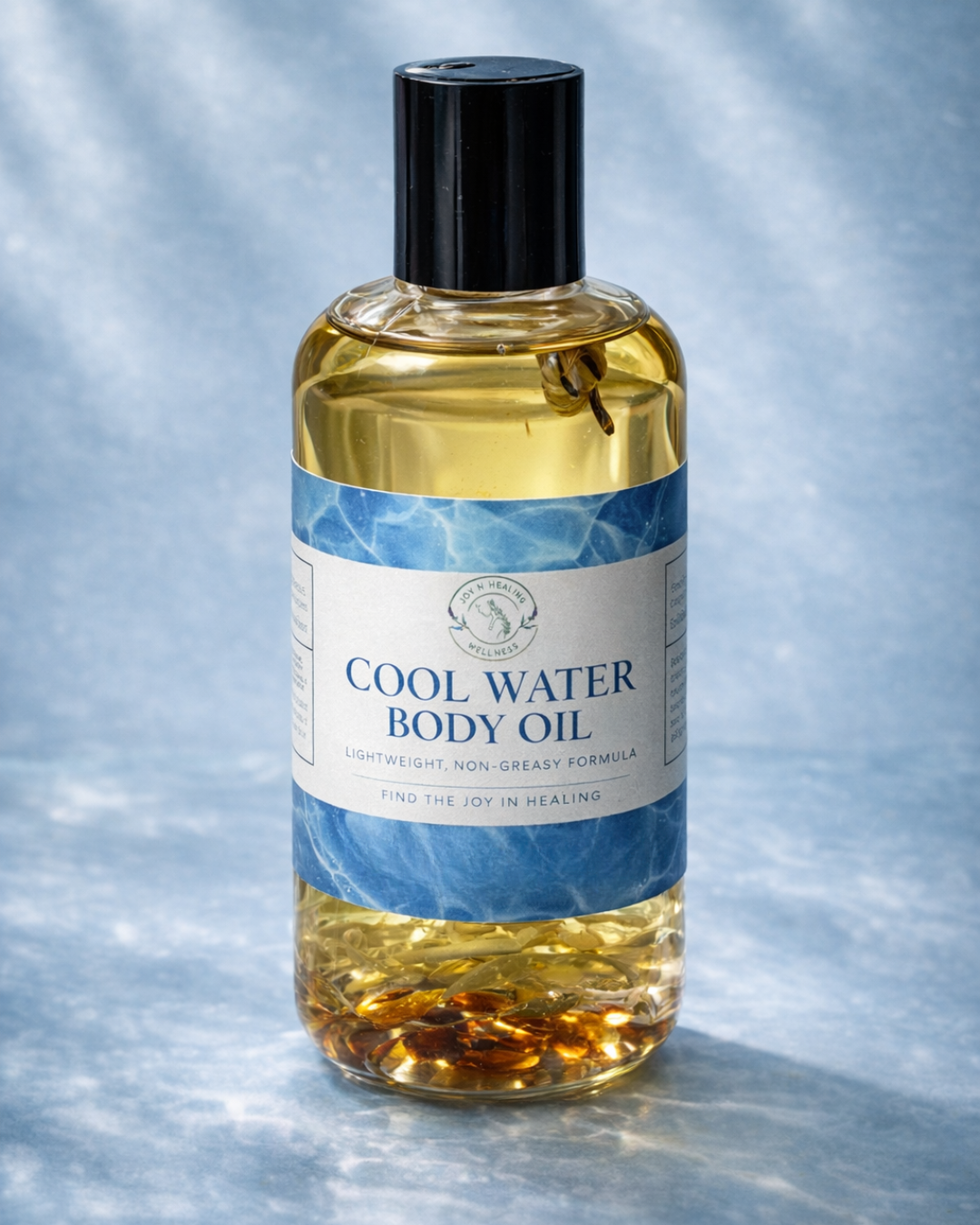 Bottle of Cool Water Body Oil on a textured gray background