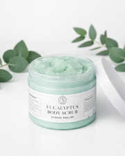 Jar of Eucalyptus Body Scrub with eucalyptus leaves on a white background